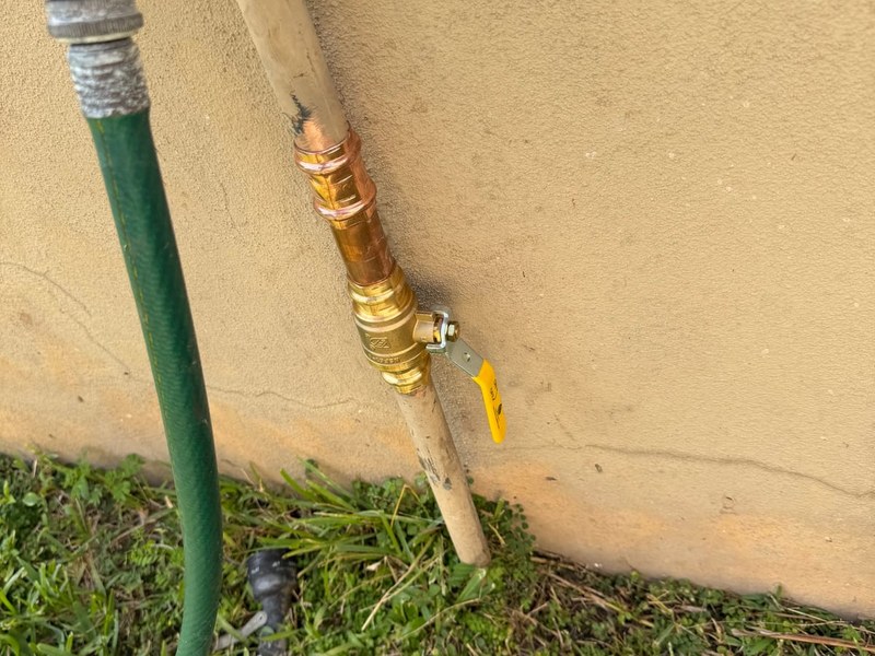 A new exterior shutoff valve and hose bib on a stucco wall, installed by Miami Dade Plumbing