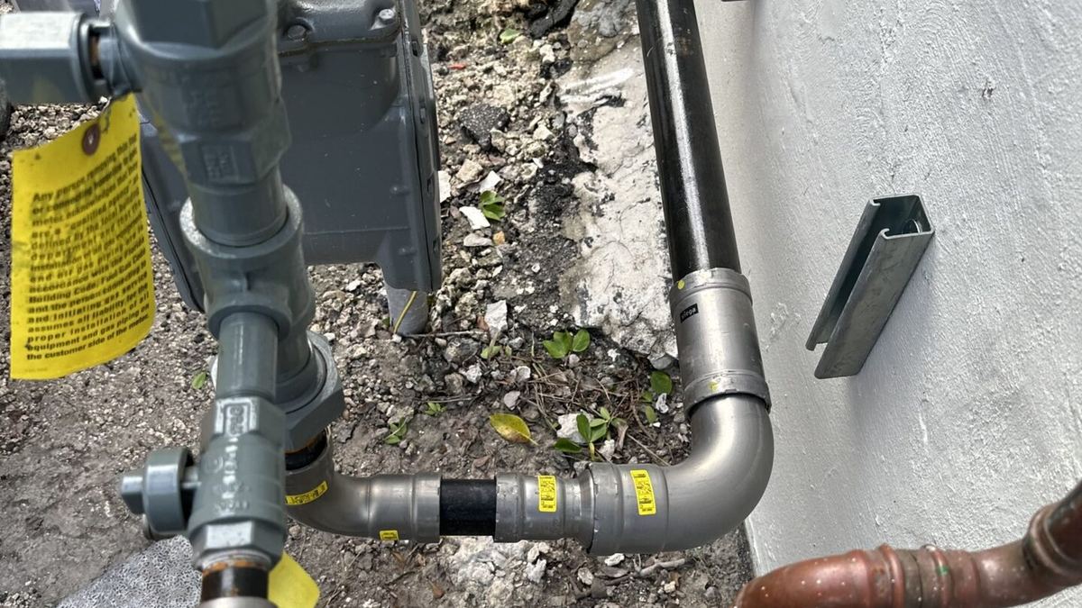 Exterior supply and gas piping on a Miami stucco wall
